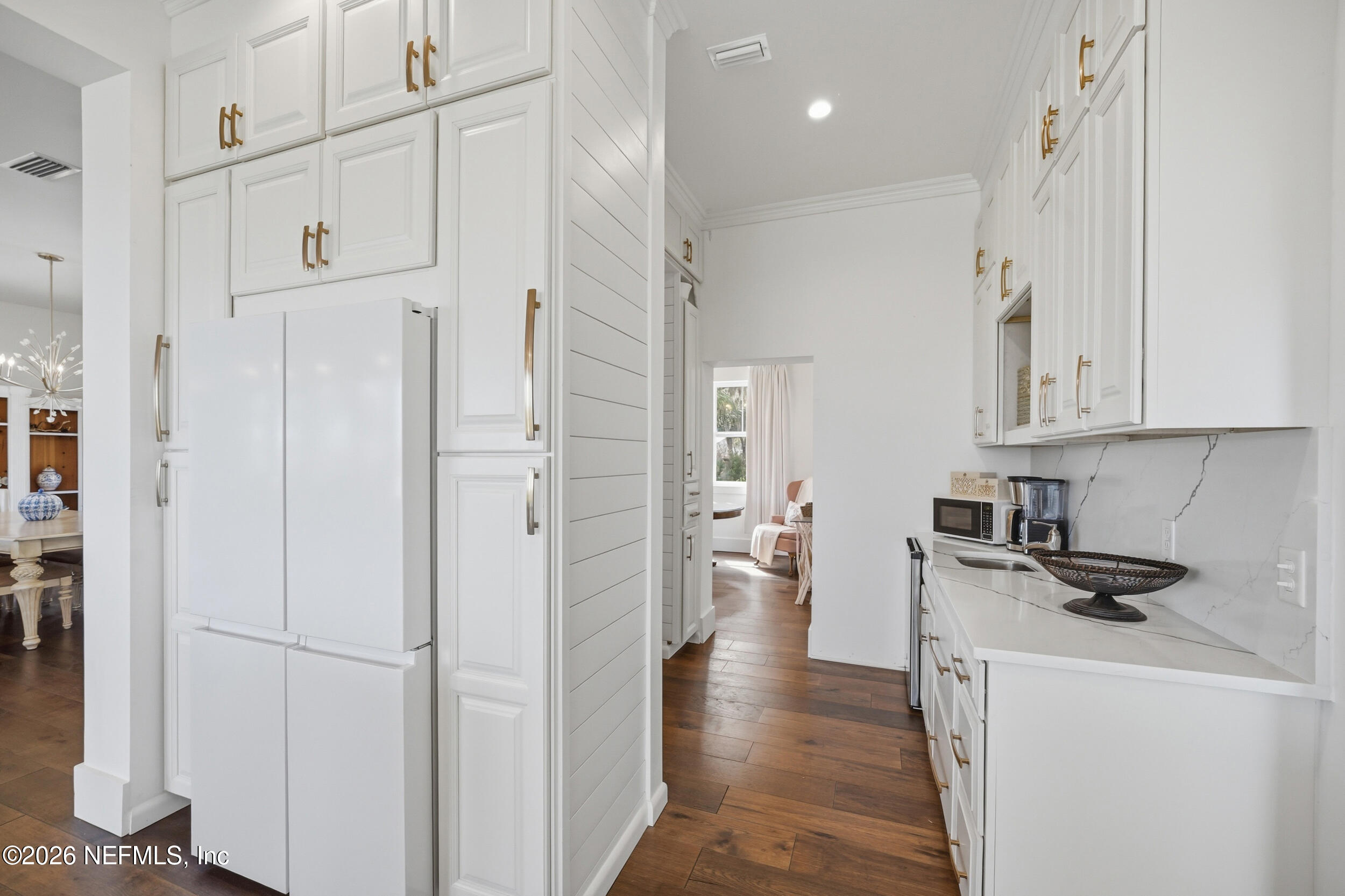 2406 Shore Drive St. Augustine, FL 32086 - Photo 27 of 108 a kitchen with stainless steel appliances white cabinets and wooden floors