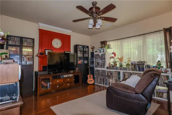 a living room with furniture a flat screen tv and a floor to ceiling window