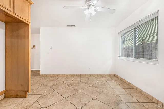 a view of an empty room with a fireplace and a window