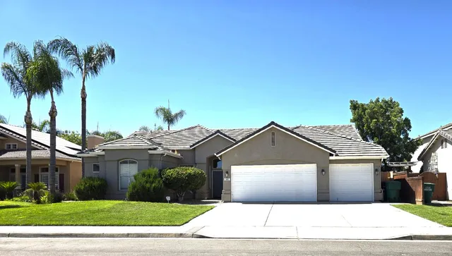 a front view of house with yard and palm tree
