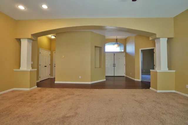 a view of an empty room with a fireplace and a window