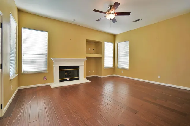 a view of an empty room with a fireplace and a window