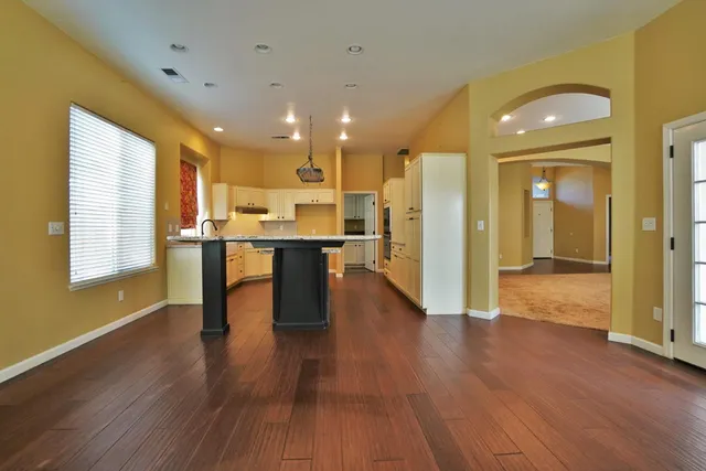 a kitchen with wooden floors wooden cabinets a sink and a stove