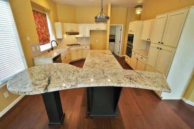 a kitchen with granite countertop white cabinets and white appliances
