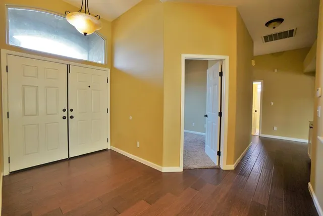 an empty room with a window and a ceiling fan