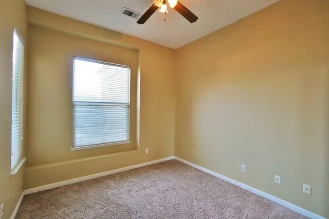 an empty room with closet and a hallway