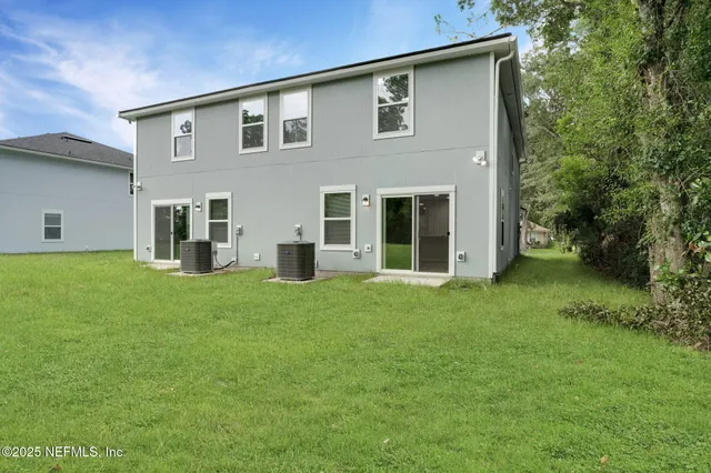 a front view of a house with a yard and trees