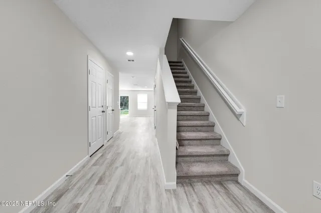 a view of entryway and hall with wooden floor