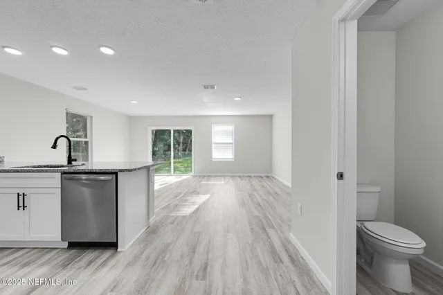 a view of a kitchen from the hallway with a washer and dryer