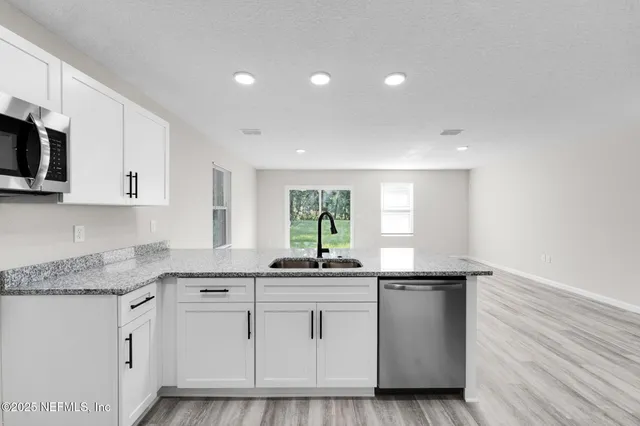 a kitchen with granite countertop a sink and cabinets
