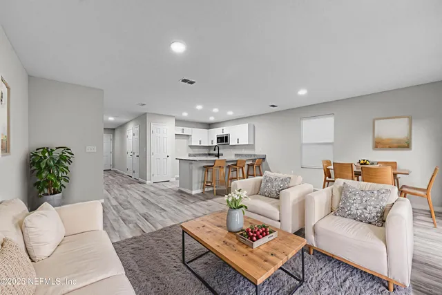 a living room with furniture kitchen view and a table