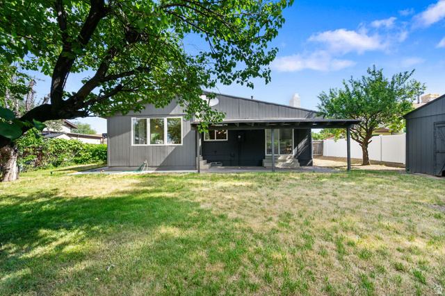 432 Calnette Drive Sandy, UT 84070 - Photo 44 of 48 Spacious backyard featuring a covered patio, mature trees providing natural shade, and a detached storage shed