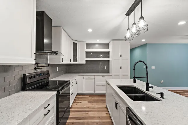 a kitchen with kitchen island granite countertop a sink stainless steel appliances and cabinets