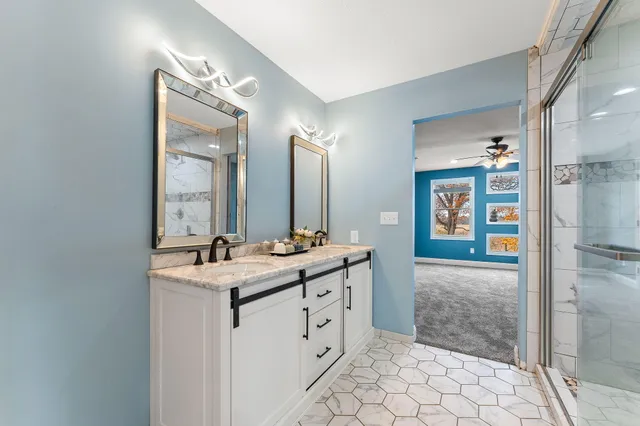 a spacious bathroom with a double vanity sink mirror and shower