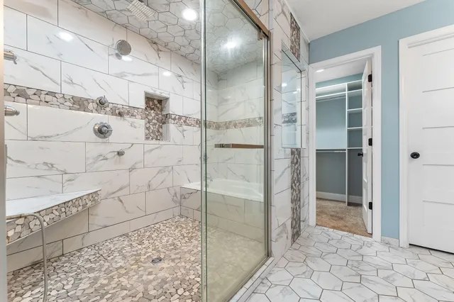 a bathroom with a glass shower door and a bathroom