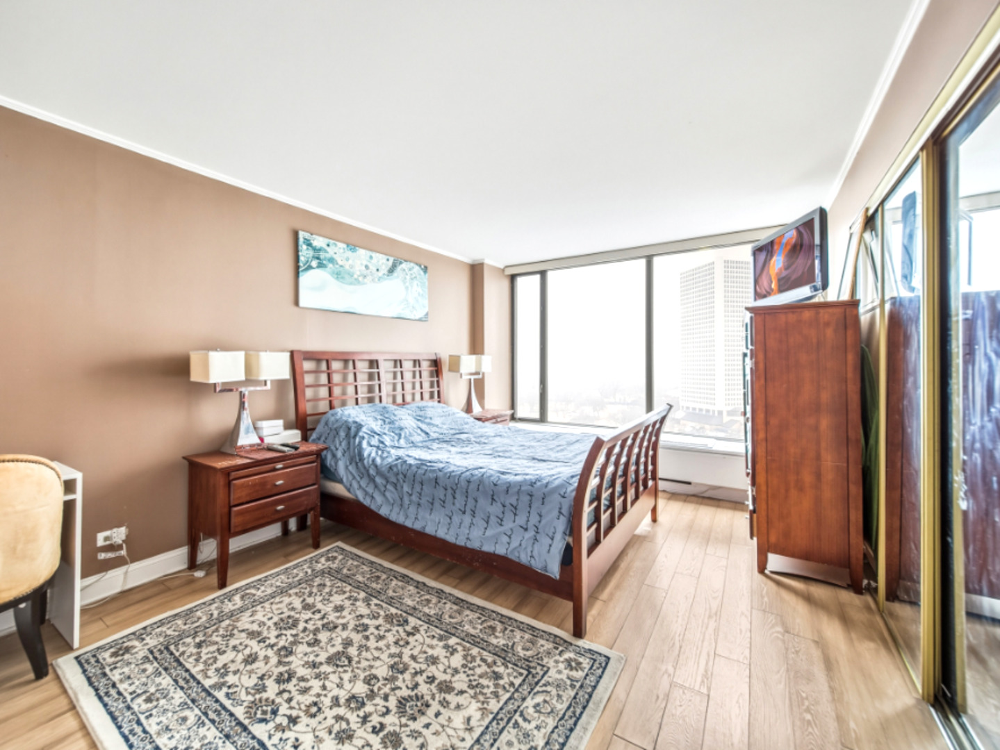5455 North Sheridan Road, Unit 1404 Chicago, IL 60640 - Photo 12 of 24 a bedroom with a bed and wooden floor