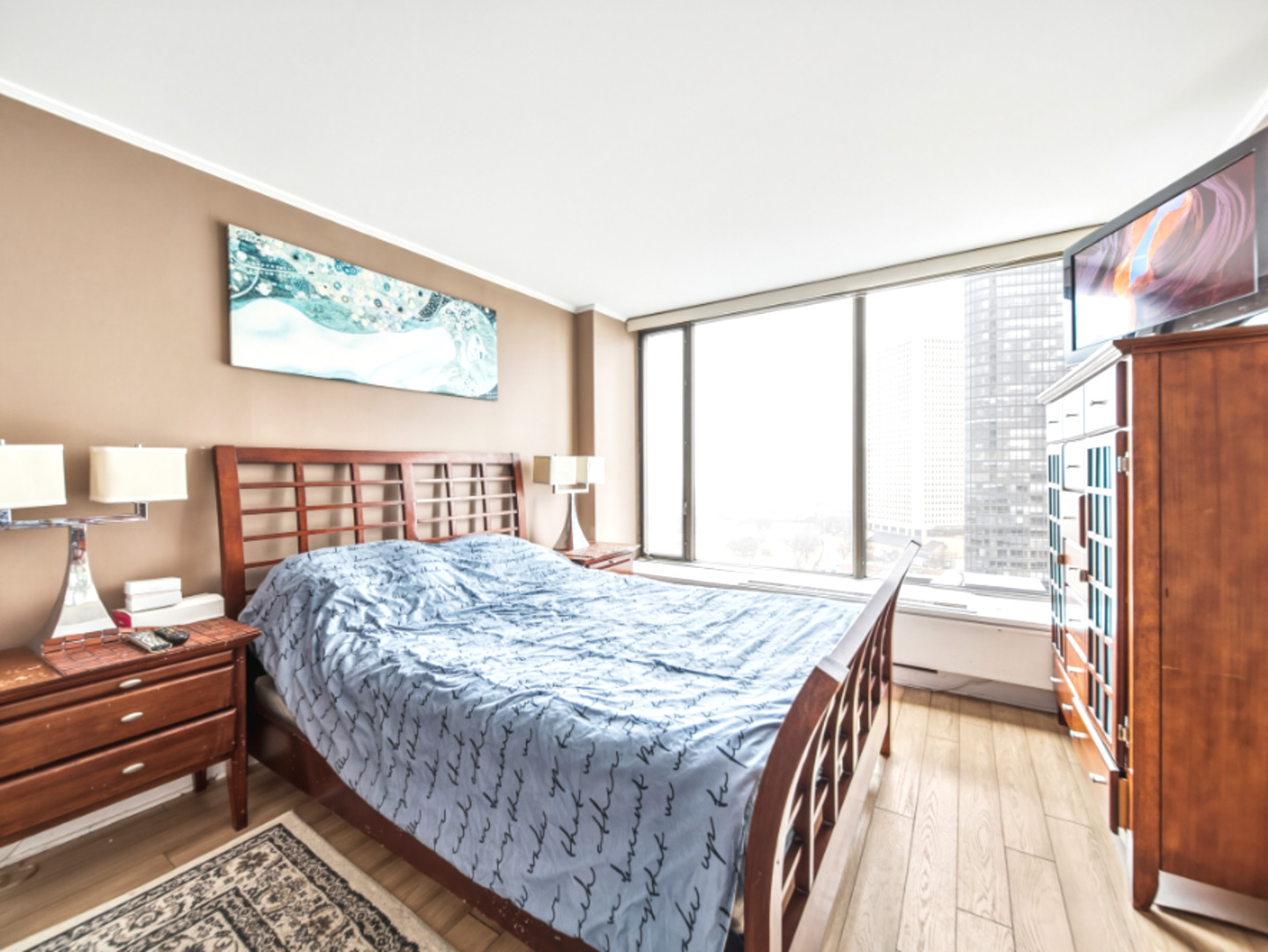 5455 North Sheridan Road, Unit 1404 Chicago, IL 60640 - Photo 13 of 24 a bedroom with a bed and wooden floor