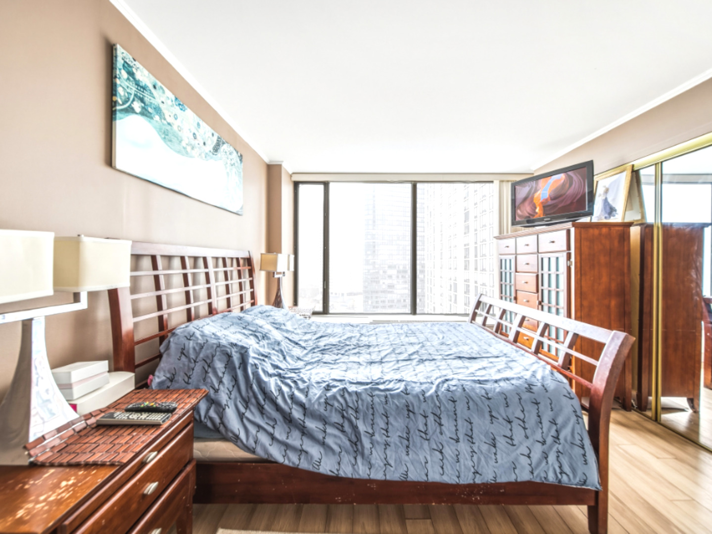 5455 North Sheridan Road, Unit 1404 Chicago, IL 60640 - Photo 14 of 24 a bedroom with a bed and wooden floor