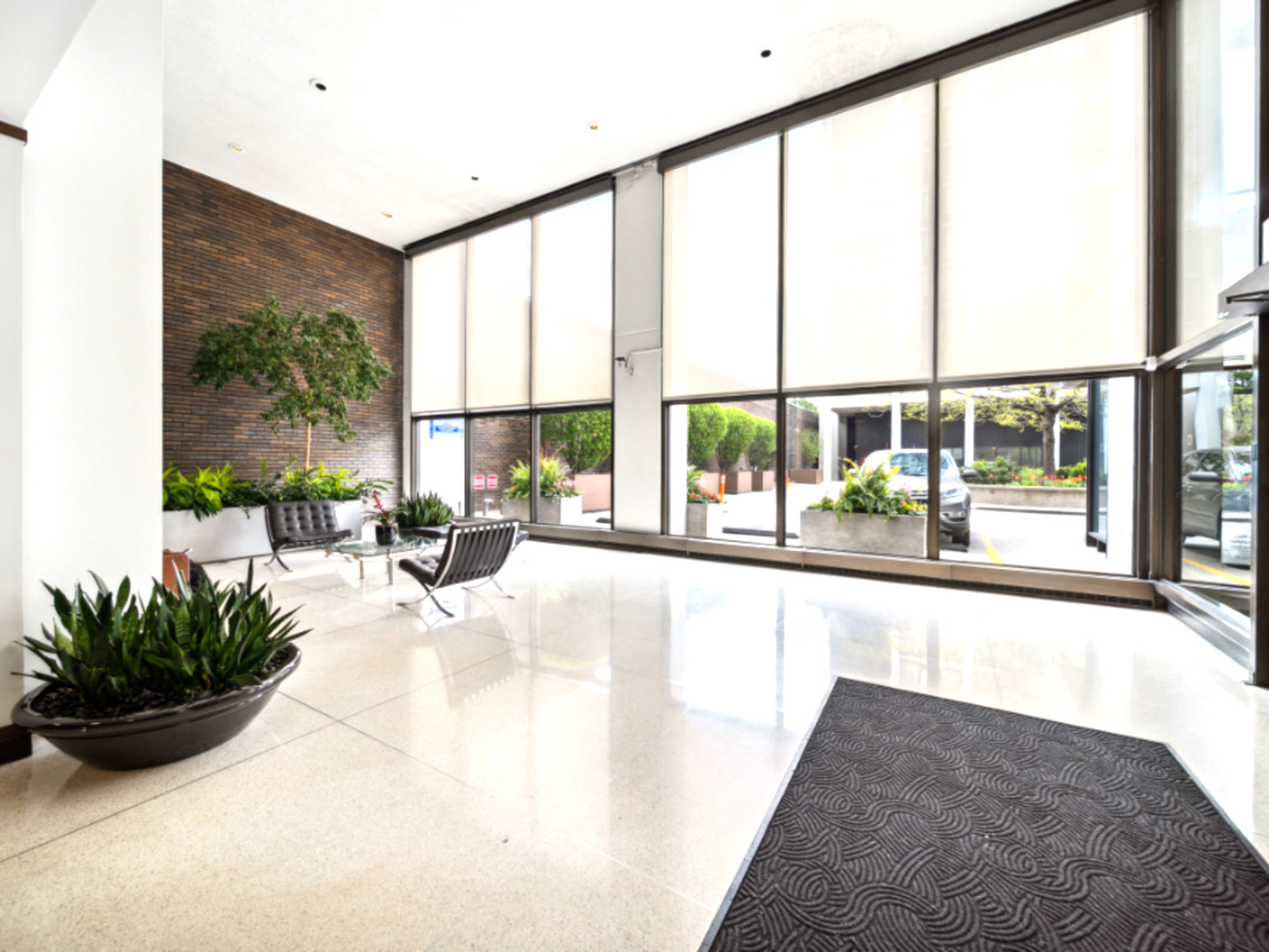 5455 North Sheridan Road, Unit 1404 Chicago, IL 60640 - Photo 2 of 24 a view of a living room with a floor to ceiling window and potted plants