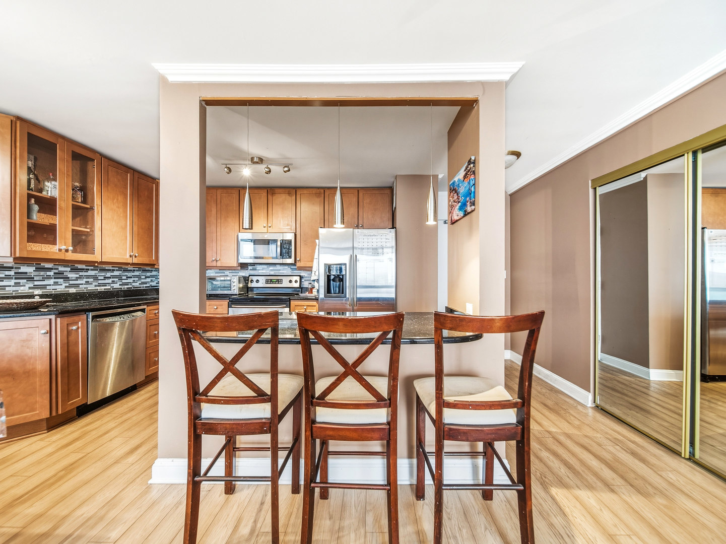 5455 North Sheridan Road, Unit 1404 Chicago, IL 60640 - Photo 6 of 24 a dining area with stainless steel appliances a dining table chairs and wooden floor