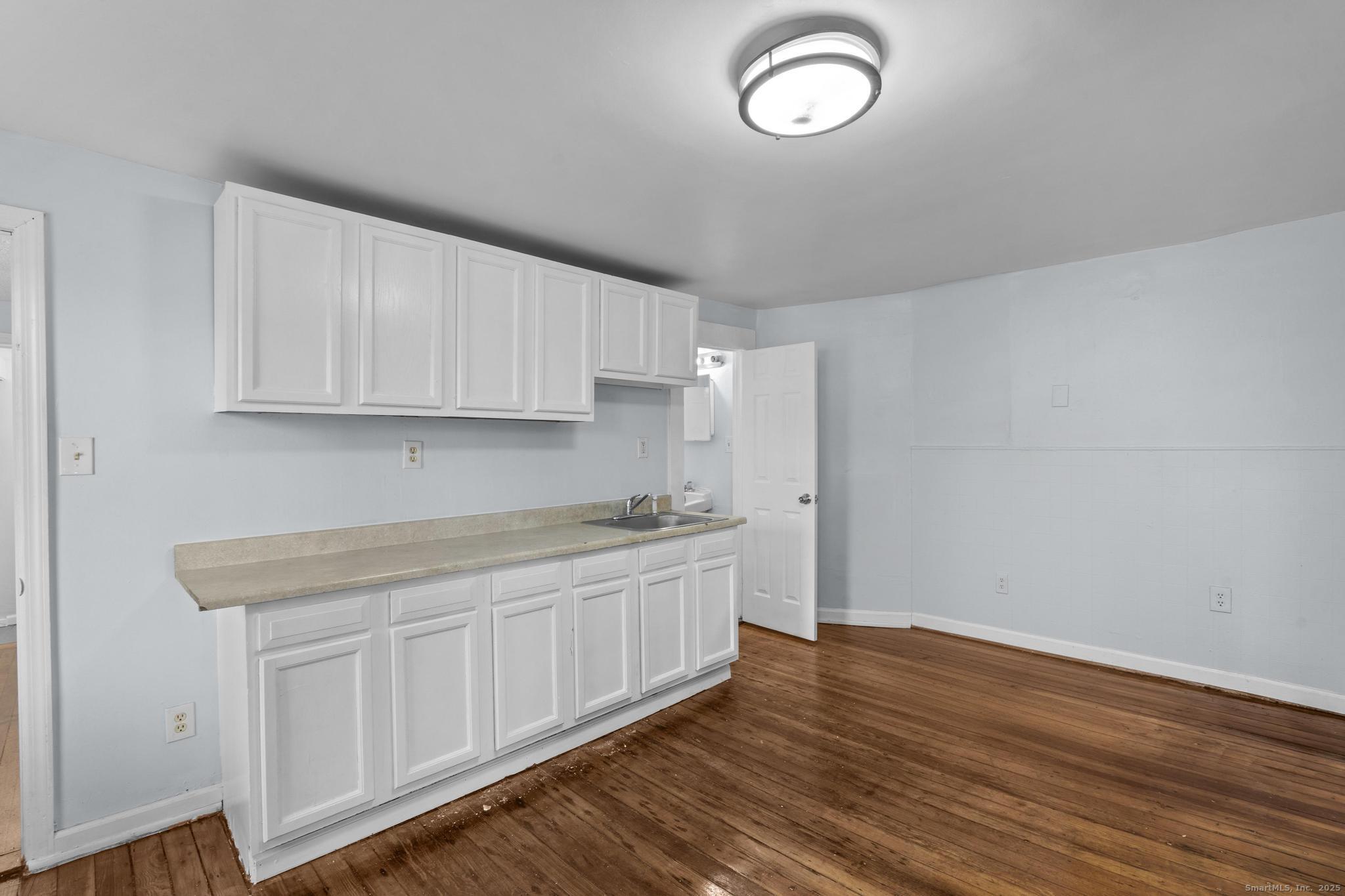 156 Orange Street Waterbury, CT 06704 - Photo 16 of 32 a kitchen with cabinets and wooden floor