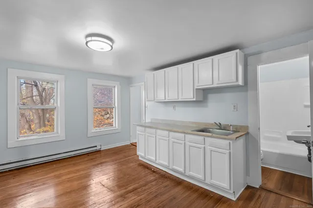 a kitchen with stainless steel appliances granite countertop white cabinets and window