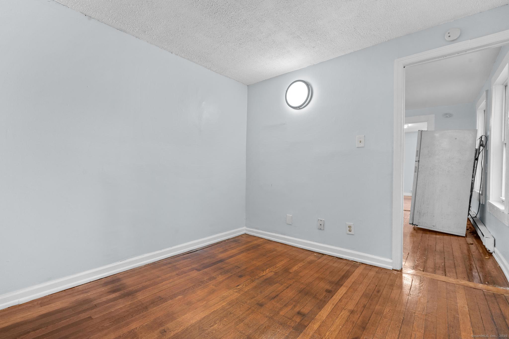 156 Orange Street Waterbury, CT 06704 - Photo 23 of 32 a view of empty room with wooden floor and window