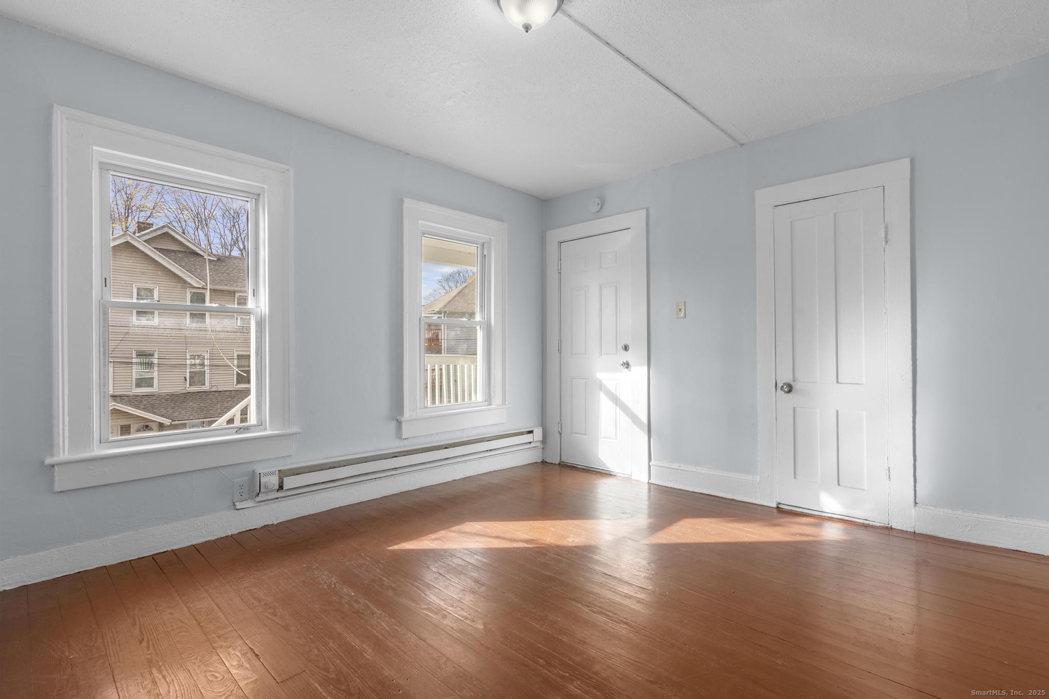 156 Orange Street Waterbury, CT 06704 - Photo 3 of 32 a view of an empty room with wooden floor and a window