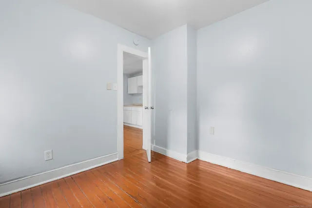 a view of an empty room with wooden floor
