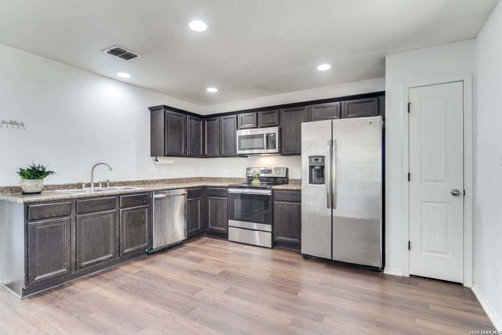 1145 Bob White Drive Spring Branch, TX 78070 - Photo 11 of 27 a kitchen with granite countertop a refrigerator and a sink
