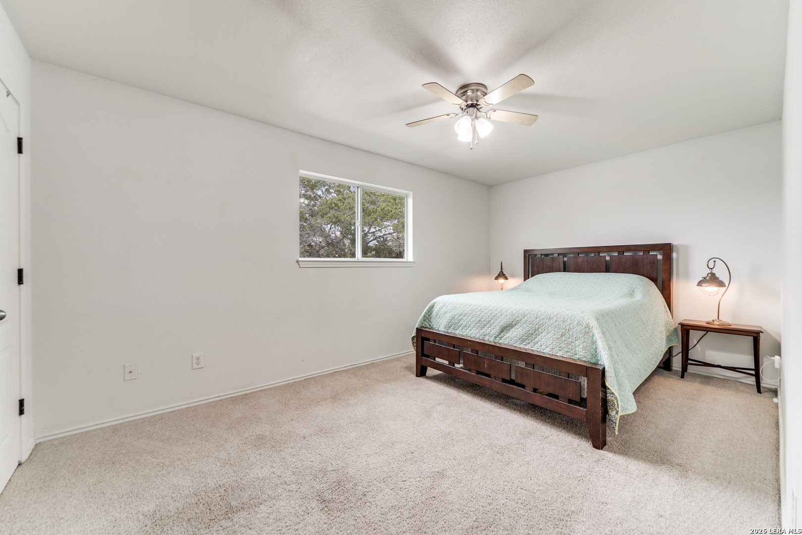 1145 Bob White Drive Spring Branch, TX 78070 - Photo 15 of 27 a spacious bedroom with a bed and a chandelier