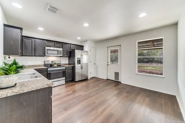a kitchen with granite countertop stainless steel appliances and wooden cabinets