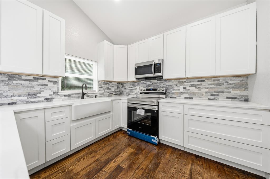 3313 South 3rd Street Waco, TX 76706 - Photo 7 of 28 a kitchen with granite countertop white cabinets appliances a sink and a window