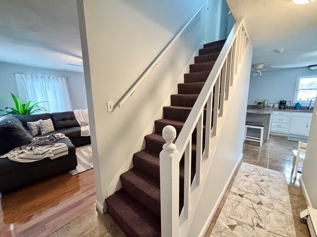 a living room with wooden floor and stairs