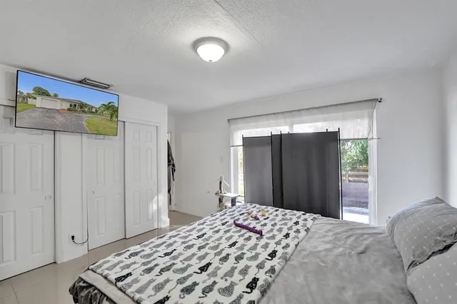 a bedroom with a bed and a flat screen tv