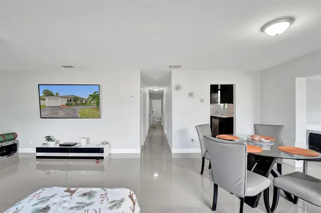 a view of a patio with table and chairs potted plants with wooden floor and fence