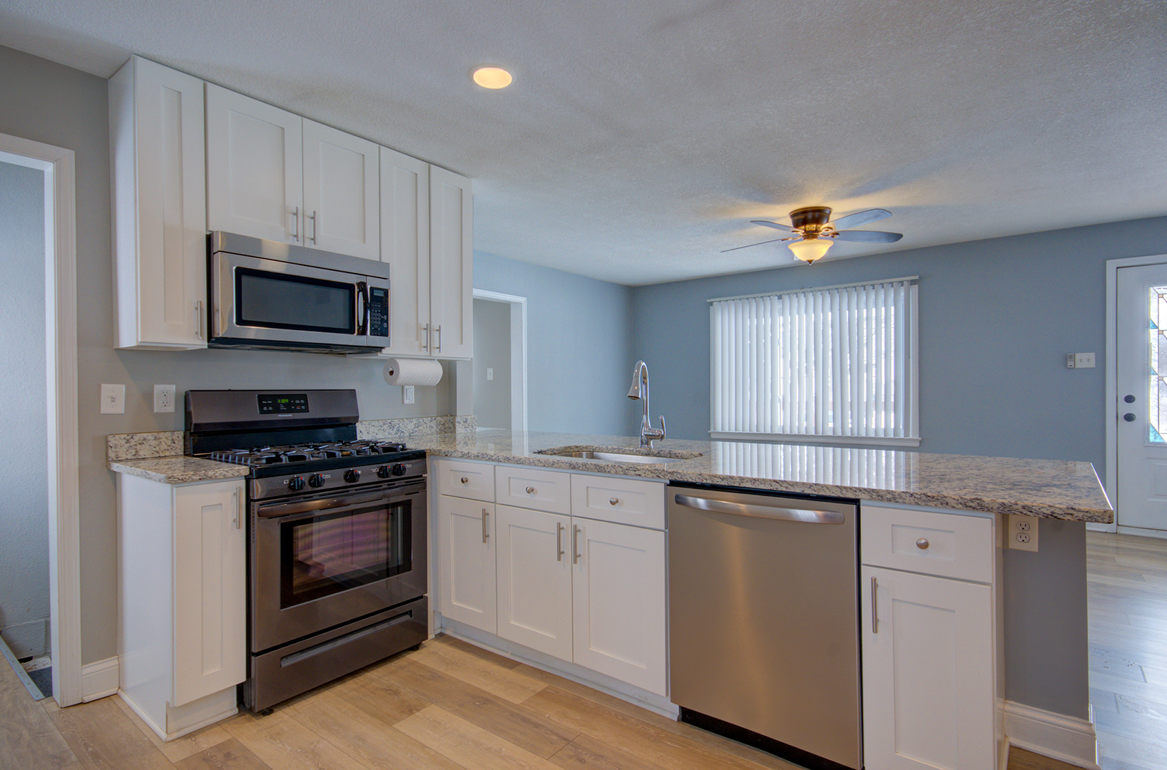 1168 South 5000W Road Kankakee, IL 60901 - Photo 8 of 30 a kitchen with granite countertop a stove a sink and a microwave