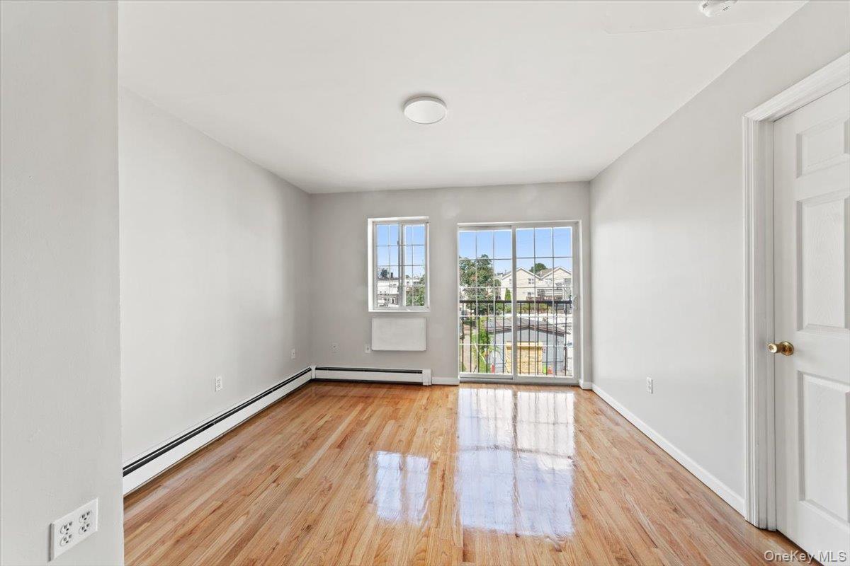 1309 Vreeland Avenue, Unit 2 Bronx, NY 10461 - Photo 5 of 13 a view of an empty room with wooden floor and a window