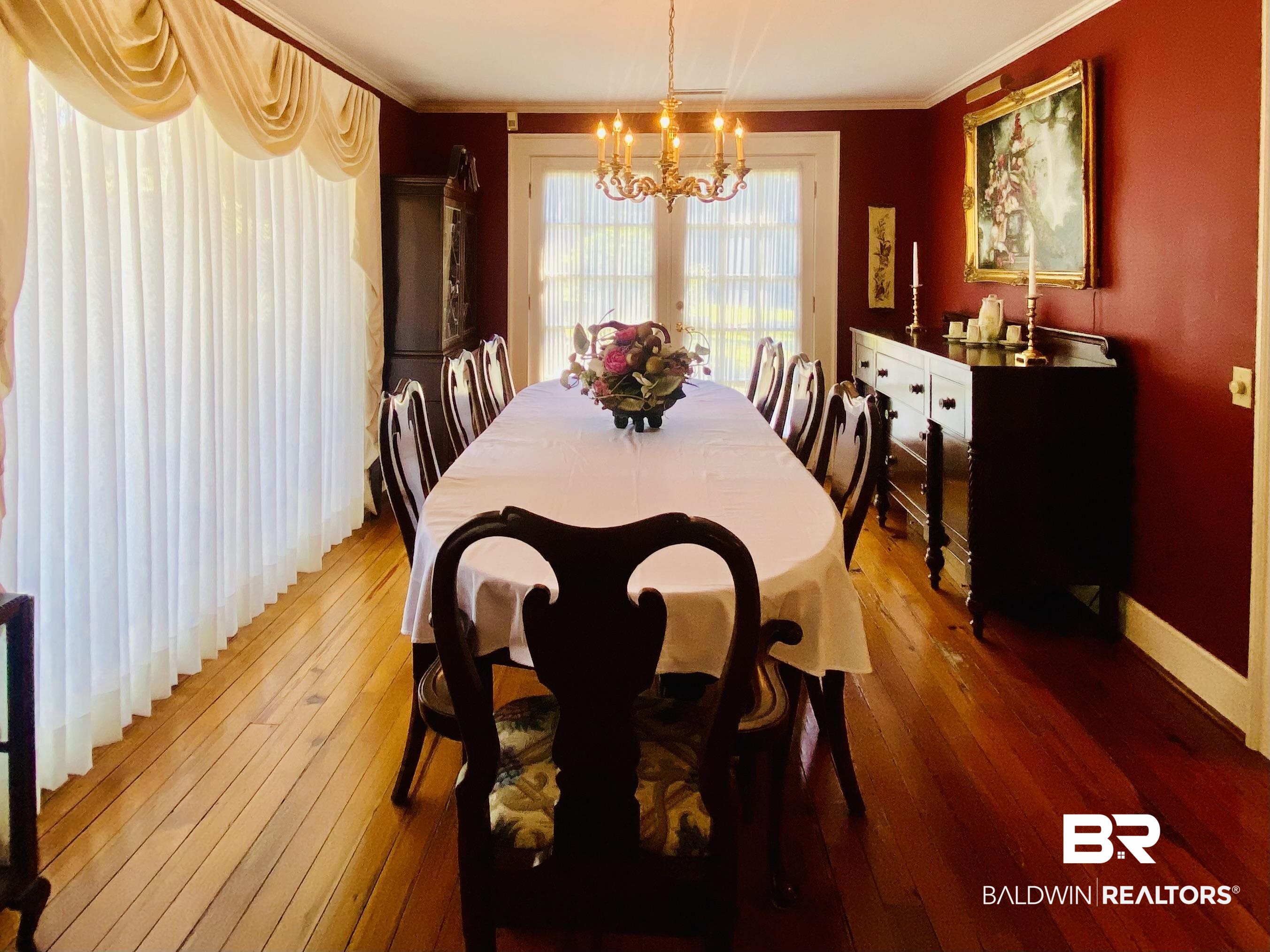 Dining room with ornamental molding, a notable chandelier, and hardwood / wood-style floors.