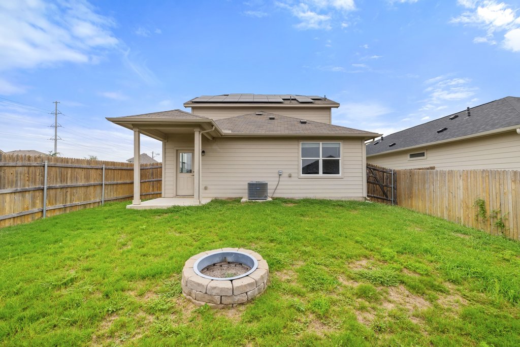 102 Ashford Way Georgetown, TX 78626 - Photo 27 of 28 A private backyard oasis features a fire pit, perfect for outdoor gatherings and relaxation.