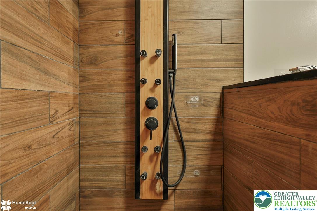 5832 Kernsville Road Orefield, PA 18069 - Photo 28 of 49 Rich wood-look plank tile walls surround a modern multi-jet shower system.