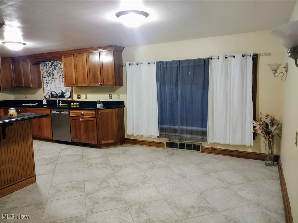 4376 22nd Street Northwest Canton, OH 44708 - Photo 7 of 10 Kitchen with brown cabinets, visible vents, dark countertops, and dishwasher
