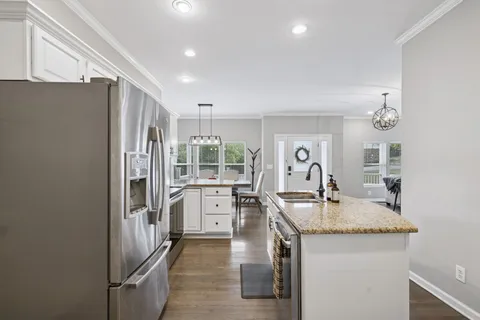 a kitchen with stainless steel appliances granite countertop a sink and a refrigerator