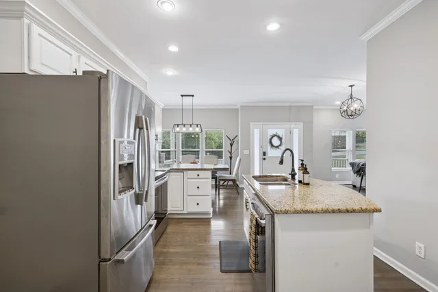a kitchen with stainless steel appliances granite countertop a sink and a refrigerator