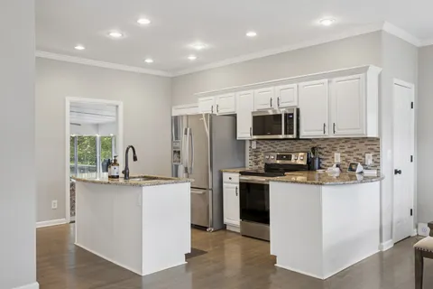a kitchen with stainless steel appliances a stove top oven a refrigerator a sink and dishwasher