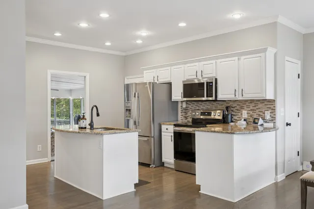 a kitchen with stainless steel appliances a stove top oven a refrigerator a sink and dishwasher