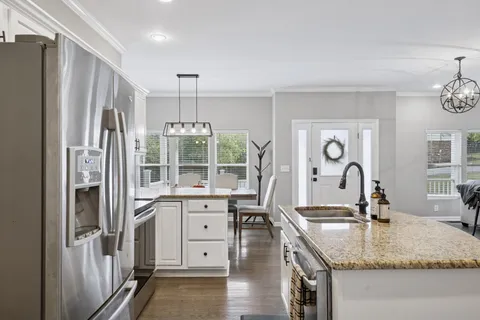 a kitchen with stainless steel appliances granite countertop a refrigerator and a sink