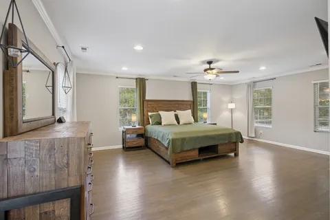 a bedroom with a large bed wooden floor and window