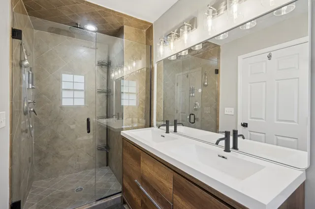 a bathroom with a sink shower and a mirror