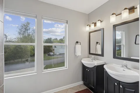 a bathroom with a double vanity sink and a mirror